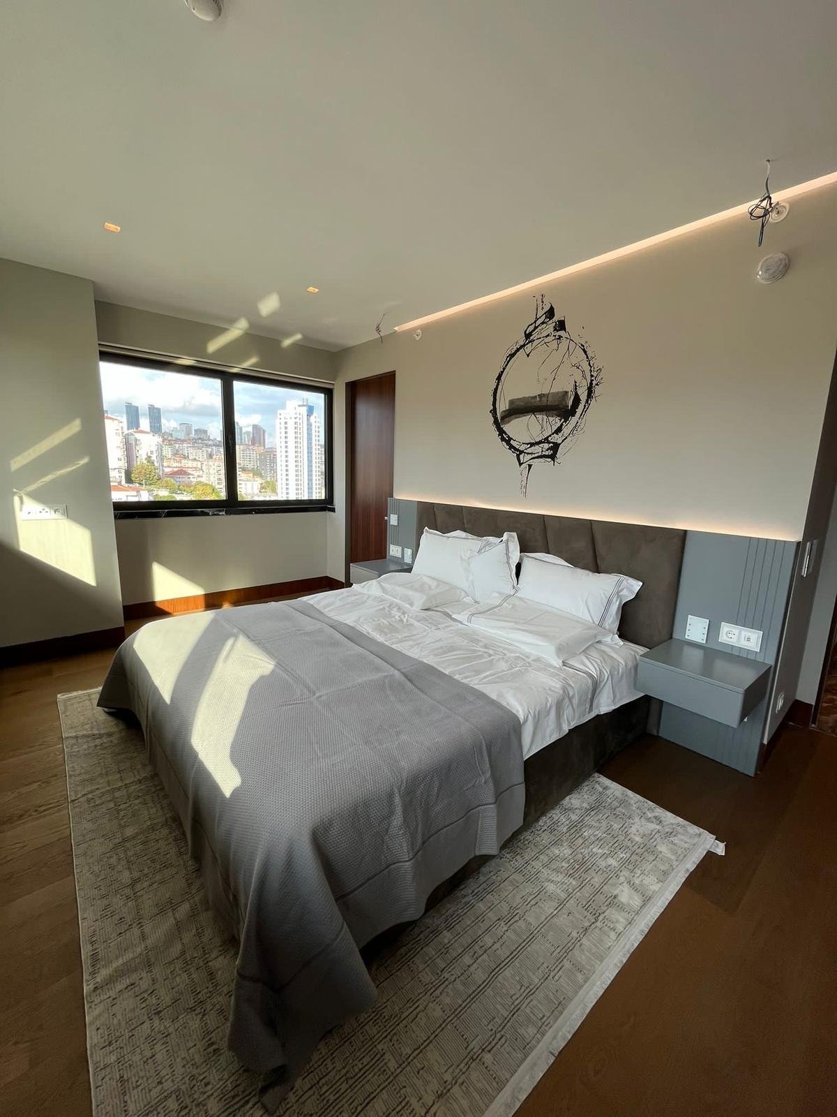 Modern bedroom with custom headboard and ambient lighting